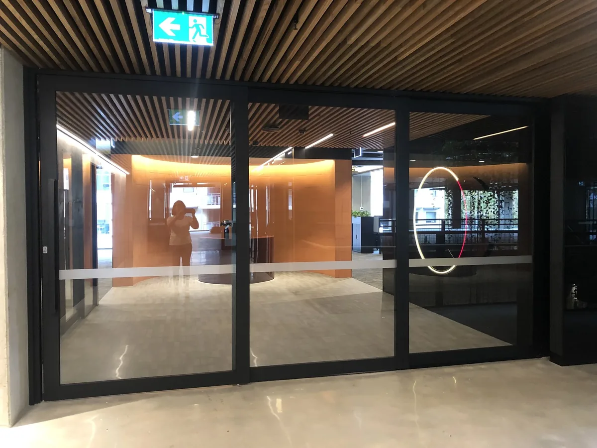 Glazed commercial entrance doors set into a timber-lined foyer