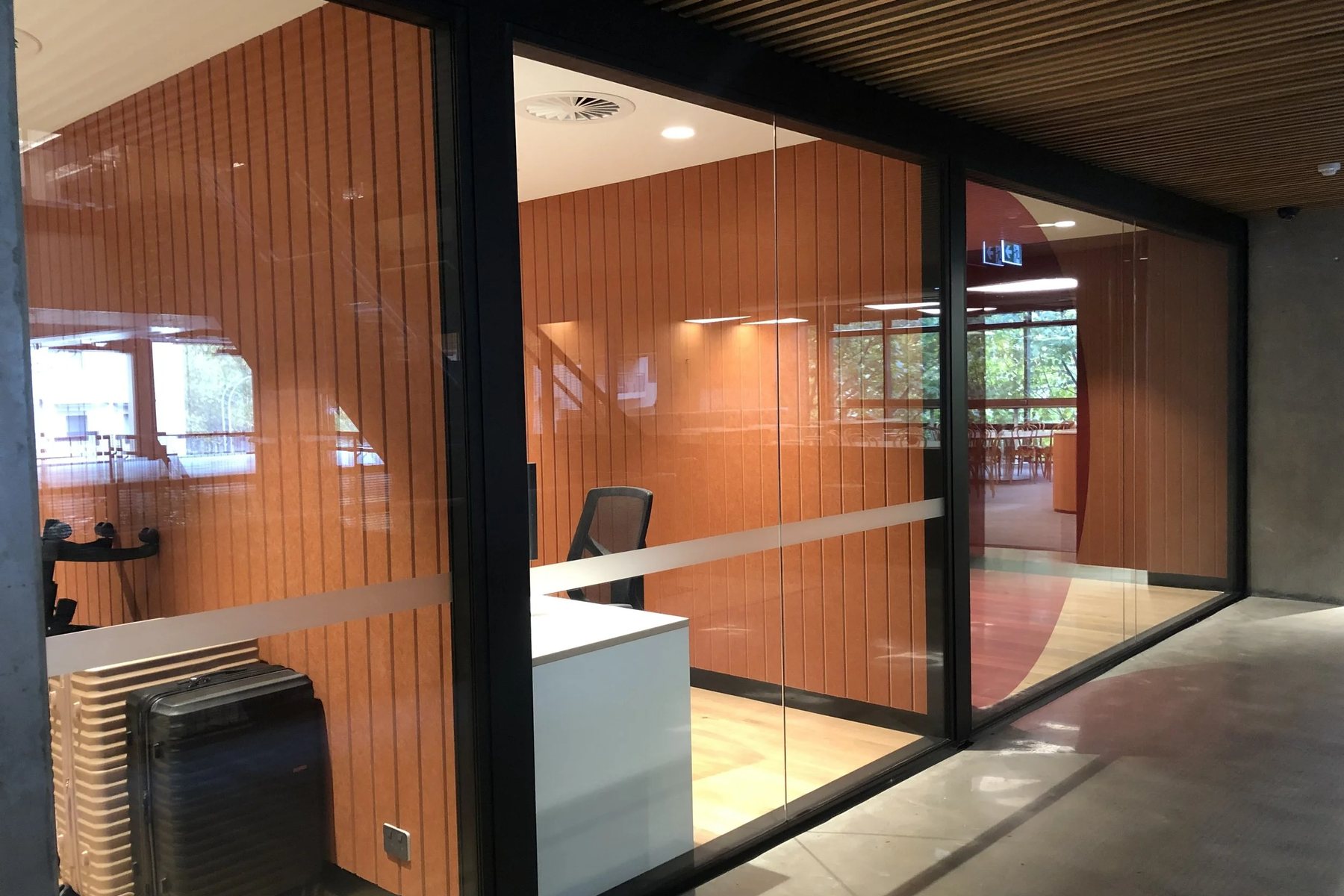Framed glass partitions dividing an open-plan office workspace