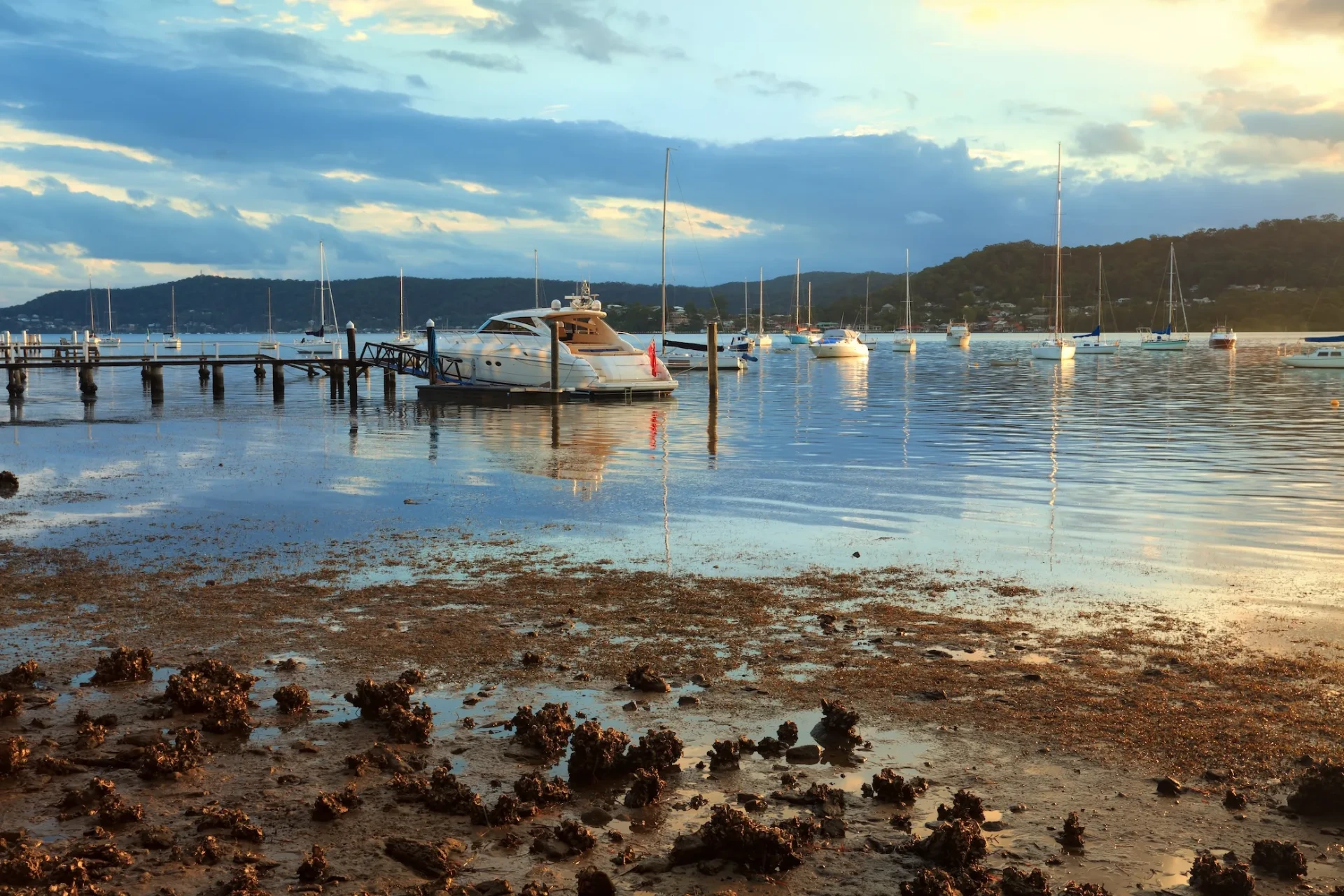 Boats moored beside a jetty on Brisbane Water at Gosford at low tide